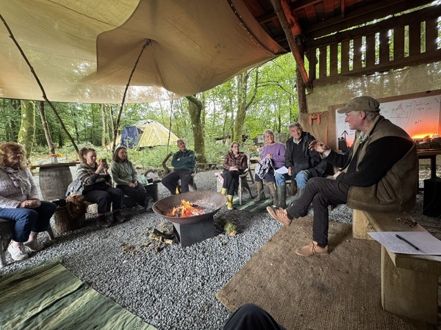 People gathered in conversation around the fire at Hensol